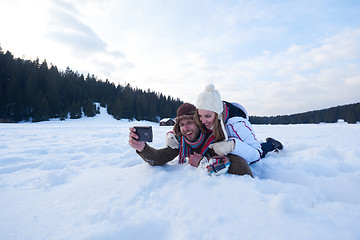 Image showing romantic couple have fun in fresh snow and taking selfie