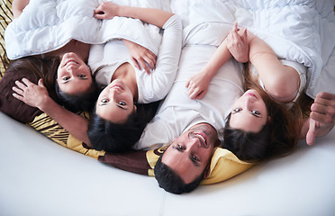 Image showing handsome man in bed with three beautiful woman