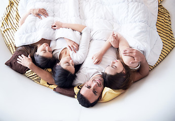 Image showing handsome man in bed with three beautiful woman