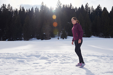 Image showing yougn woman jogging outdoor on snow in forest