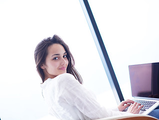 Image showing relaxed young woman at home working on laptop computer