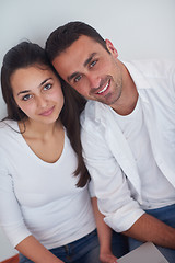 Image showing relaxed young couple working on laptop computer at home