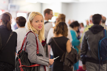 Image showing Young blond caucsian woman waiting in line.