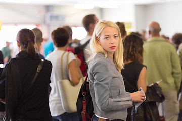 Image showing Young blond caucsian woman waiting in line.