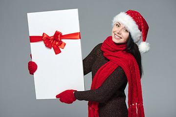 Image showing Woman in Santa hat holding white banner