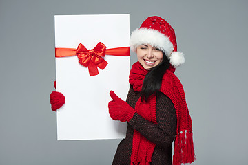 Image showing Woman in Santa hat holding white banner