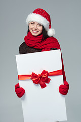 Image showing Woman in Santa hat holding white banner