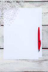 Image showing The blank sheet of paper on the wooden table with a pen 