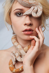 Image showing Beautiful girl and the snake Boa constrictors, which wraps around her face