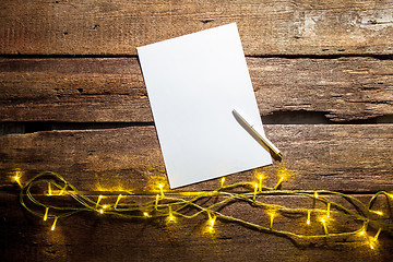 Image showing The blank sheet of paper on the wooden table with a pen 