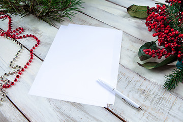 Image showing The blank sheet of paper on the wooden table with a pen 