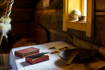 Image showing Rural vintage wood kitchen table with books and cooking utensils around 