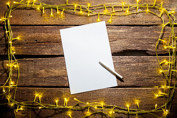 Image showing The blank sheet of paper on the wooden table with a pen 