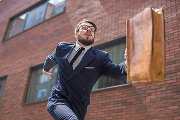 Image showing young businessman running in a city street