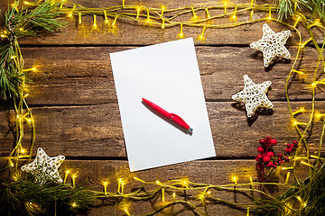 Image showing The blank sheet of paper on the wooden table with a pen 