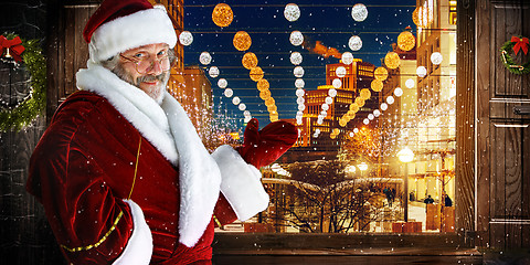 Image showing The man in costume of santa claus over  night city background