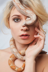 Image showing Beautiful girl and the snake Boa constrictors, which wraps around her face