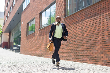 Image showing african black young businessman running in a city street