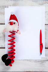 Image showing The blank sheet of paper on the wooden table with a pen 