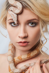 Image showing Beautiful girl and a python, which wraps around her body