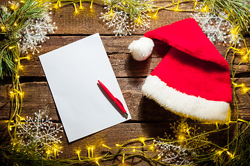 Image showing The blank sheet of paper on the wooden table with a pen 