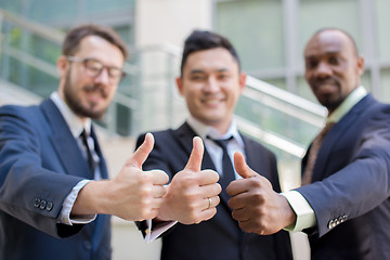 Image showing Close-up of business team holding their thumbs up