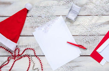 Image showing The blank sheet of paper on the wooden table with a pen 