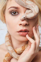 Image showing Beautiful girl and the snake Boa constrictors, which wraps around her face