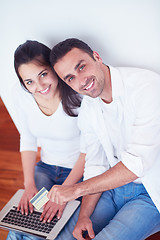 Image showing relaxed young couple working on laptop computer at home