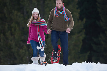 Image showing couple having fun and walking in snow shoes