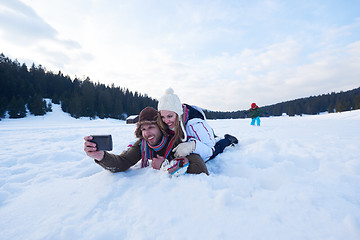 Image showing romantic couple have fun in fresh snow and taking selfie