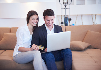 Image showing relaxed young couple working on laptop computer at home