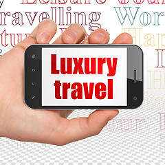 Image showing Vacation concept: Hand Holding Smartphone with Luxury Travel on display