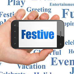 Image showing Entertainment, concept: Hand Holding Smartphone with Festive on display