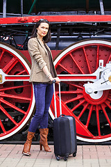 Image showing woman with luggage near the old steam locomotive