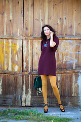 Image showing woman in a burgundy dress with a handbag