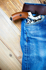 Image showing revolver nagant in the pocket of old blue jeans