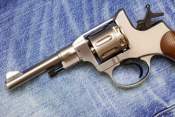 Image showing Nagan revolver on old blue jeans