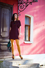 Image showing pretty middle-aged woman in a burgundy dress and pantyhose musta