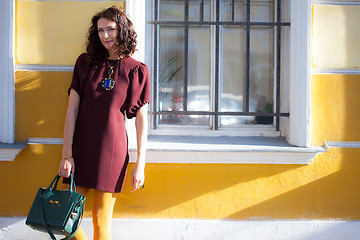 Image showing smiling middle-aged woman in a burgundy dress