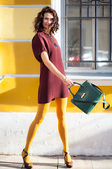 Image showing laughing middle-aged woman with a green handbag