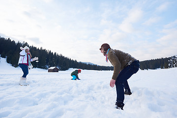 Image showing happy family playing together in snow at winter