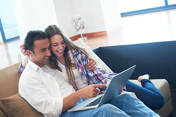 Image showing relaxed young couple working on laptop computer at home