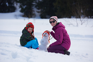 Image showing happy family building snowman