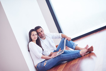 Image showing relaxed young couple working on laptop computer at home