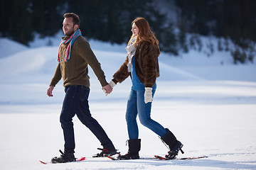 Image showing couple having fun and walking in snow shoes