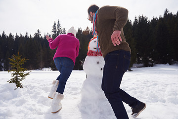 Image showing happy family building snowman