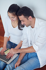 Image showing relaxed young couple working on laptop computer at home