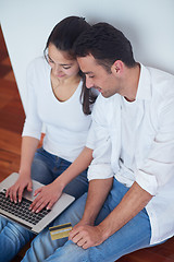 Image showing relaxed young couple working on laptop computer at home