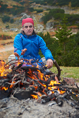 Image showing hiking man prepare tasty sausages on campfire